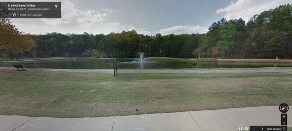 Lake on property with fountain
