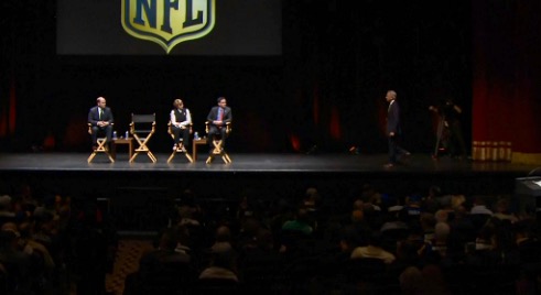 NFL exec VP Eric Grubman stands on stage while answering a question at the Oakland Town Hall